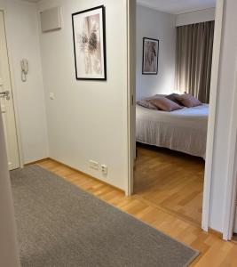 a room with a bedroom with a bed and a doorway at Tasokas jokiranta-asunto lähellä ydinkeskustaa in Turku