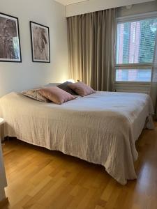 a bed in a bedroom with a large window at Tasokas jokiranta-asunto lähellä ydinkeskustaa in Turku