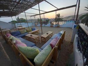 BAYT ZAINA - Nubian hospitality house في أسوان: مجموعة من الأرائك والوسائد على الشاطئ
