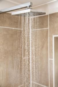 a shower with a shower head with crystals at Centrally Located accommodation near town center in Kent