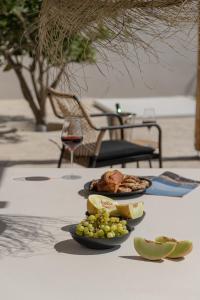 a table with two plates of food and a glass of wine at Golden Sand Villas with Private Pool in Vívlos
