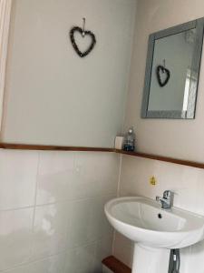 a bathroom with a sink and two hearts on the wall at Stiwdio Eithinog in Caernarfon