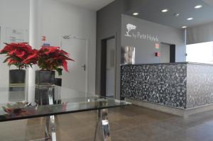 un vestíbulo con una encimera de cristal con flores rojas. en Madeira Bright Star by Petit Hotels en Funchal
