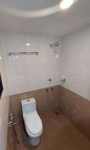W pokoju znajduje się łazienka z białą toaletą. w obiekcie FOUR SQUARE COMFORTS w mieście Manipala