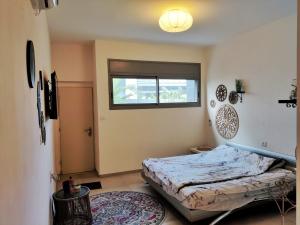 a bedroom with a bed and a window at נקודות ריפוי in Tirat Karmel