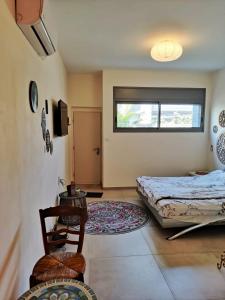 Tirat Karmelにあるנקודות ריפויのベッドルーム1室(ベッド1台、テーブル、椅子付)