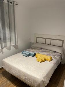 a bedroom with a bed with two objects on it at Apartamento El Azul in Molina de Segura