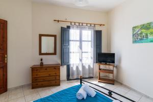 a bedroom with a bed and a tv and a window at Soulis Hotel in Oia