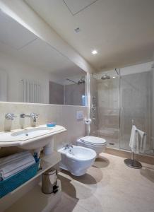 La salle de bains est pourvue d'un lavabo, de toilettes et d'une douche. dans l'établissement Rambaldi Apartments Casa nr 1, à Bardolino
