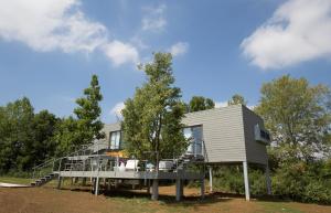 a tiny house with a large deck and trees at Eco Bio Agriturismo La Bella Vite - Camere Con Vigna in Carpeneto