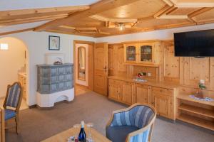 a large kitchen with wooden cabinets and a tv at Landhaus Marion in Holzgau