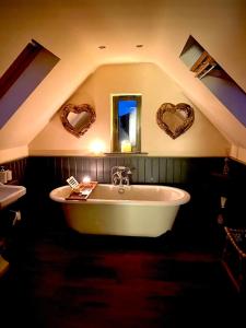 a bathroom with a white tub and hearts on the wall at TreeTops in Barlow