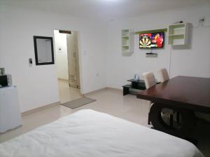 a white room with a table and a television at Royal guesthouse in Opuwo