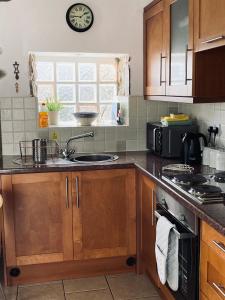 uma cozinha com um lavatório e um fogão forno superior em Eithin Bach em Caernarfon
