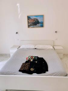 a white bed with a black bag on it at Bed & Breakfast Sweet life La spezia Liguria in La Spezia