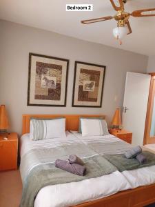 een slaapkamer met een groot bed met twee handdoeken erop bij Central Self Catering in Swakopmund +52 foto's