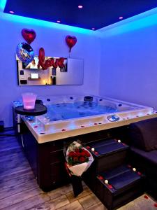 uma banheira de hidromassagem num quarto com balões de coração em Cocoon Douce Heure em Bas-Warneton
