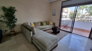 a living room with a couch and a large window at My Cosy Place Rabat - Skhirat 2min de la plage avec Piscine in Skhirat