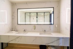 a bathroom with two sinks and a mirror at The Club Hotel Gijang Yeonhwari in Busan