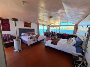 een kamer met 2 bedden en een tafel en stoelen bij TITICACA JALTAWI LODGE in Puno