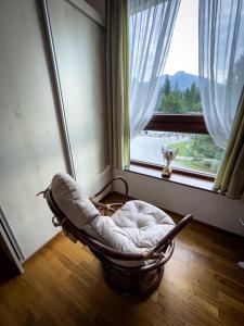a rocking chair in a room with a large window at Apartmán Crocus 313 in Štrbské Pleso