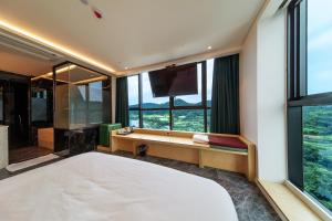 a bedroom with a large bed and a large window at The Club Hotel Gijang Yeonhwari in Busan