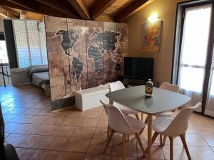 Pokój ze stołem i krzesłami oraz telewizorem w obiekcie Stea monolocale in villa w mieście Sommariva del Bosco