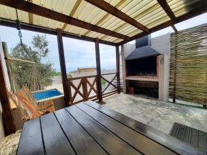 a screened in porch with a wooden table and a fireplace at Bel-Posto, Langebaan in Langebaan
