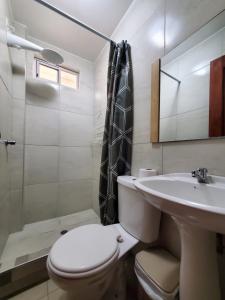 a bathroom with a toilet and a sink and a shower at Metrópolis Apartaments for Rent in Guayaquil