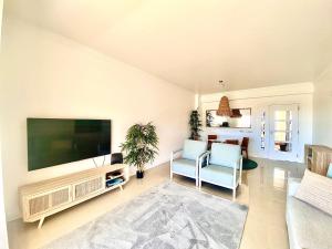 uma sala de estar com uma grande televisão de ecrã plano em Vilamoura Avelãs Ocean View Apartment em Vilamoura