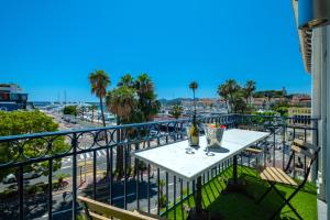a table on a balcony with a view of a city at Croisette Luxury Waterfront across the sea in Cannes