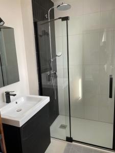 uma casa de banho com um lavatório e uma cabina de duche em vidro. em Villa au calme dans un écrin de verdure em Aytré