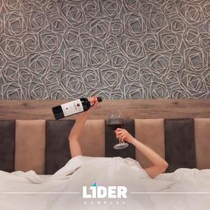 una mujer acostada en la cama con una copa de vino en Hotel Lider Complex, en Vaykʼ