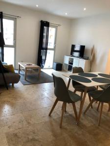uma sala de estar com mesa e cadeiras em Appartement T3 dans maison neuve 7 couchages em La Seyne-sur-Mer