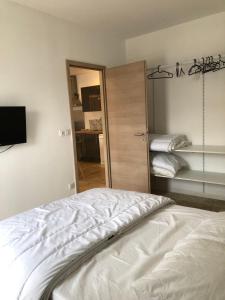 um quarto com uma cama branca e um espelho em Appartement T3 dans maison neuve 7 couchages em La Seyne-sur-Mer