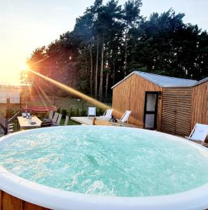 een grote hot tub in een achtertuin met zonsondergang bij Domek wakacyjny, nad morzem z balią, Lawendowe Wzgórze, in Karwieńskie Błoto Pierwsze