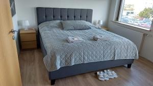 um quarto com uma cama e 2 chinelos no chão em Comfortable Bedrooms - King size beds em Hafnarfjördur