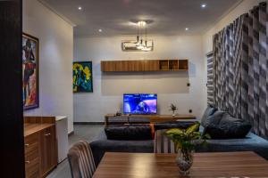 a living room with two couches and a tv at Nelson Mandela Gardens in Okpanam