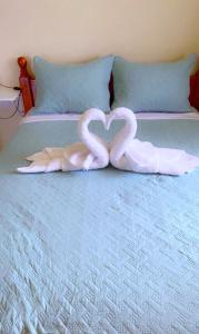 Dos cisnes formando un corazón en una cama en The Golden Inn en Marigot