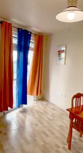 The Golden Inn في Marigot: غرفة مع ستائر حمراء وزرقاء وطاولة