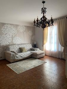 een woonkamer met een bank en een kroonluchter bij Le Lanterne - Villa vista mare in Massarosa