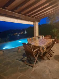 Le Lanterne - Villa vista mare في ماساروسا: طاولة وكراسي على الفناء في الليل