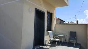 a door to a balcony with two chairs and a table at ALIKO's peaceful house, close to bus terminal in Tirana