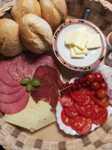 eine Platte mit Käse, Fleisch und Brot auf dem Tisch in der Unterkunft Jennys Hofladen in Usedom Town