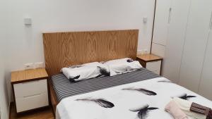 a bedroom with a bed with a wooden headboard at ALIKO's peaceful house, close to bus terminal in Tirana