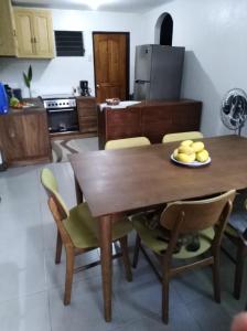 a kitchen with a wooden dining table and chairs at Cozy 1-bedroom house in quiet residential village. in Iloilo City