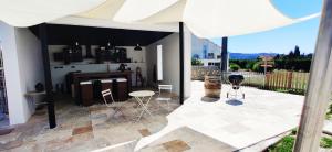 une terrasse avec un parasol blanc et une cuisine dans l'établissement Superbe chambre avec terrasse, parking privé, jardin, calme, climatisation, 10 mn pont du Gard #7, à Rochefort-du-Gard