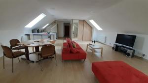 ein Wohnzimmer mit einem Tisch und einem roten Sofa in der Unterkunft Abra-fed apartament Kalinówka in Lublin