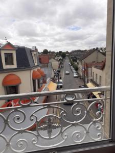 a view of a city street from a balcony at Studio Neptune in Arromanches-les-Bains