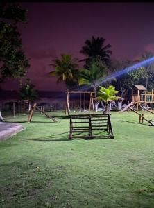 a park with a bench in the grass with palm trees at Casa Sol e Mar Beira-mar in Ilhéus +43 photos